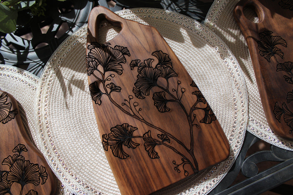 Wooden cutting board with floral engravings on a textured surface