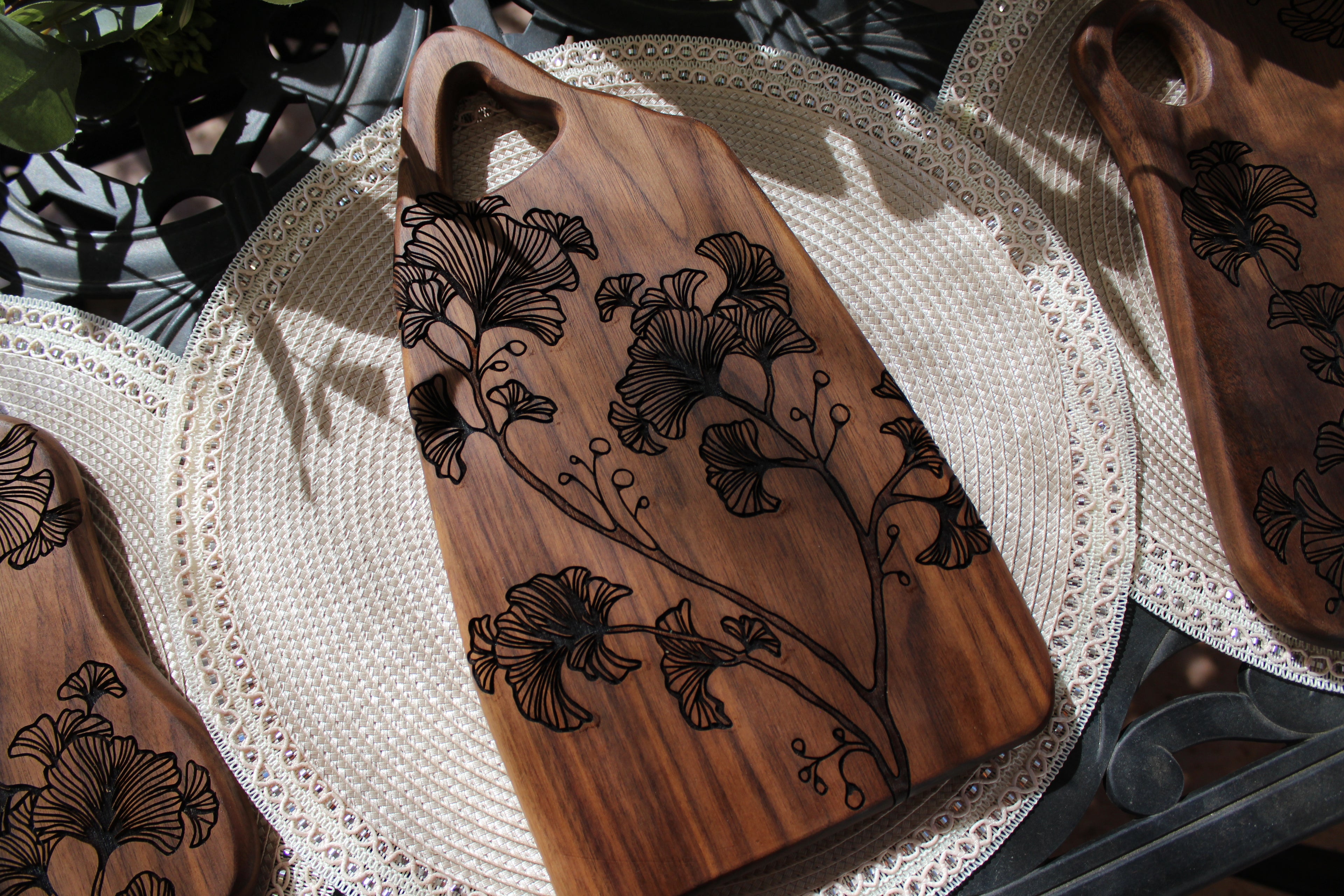 Wooden cutting board with floral engravings on a textured surface